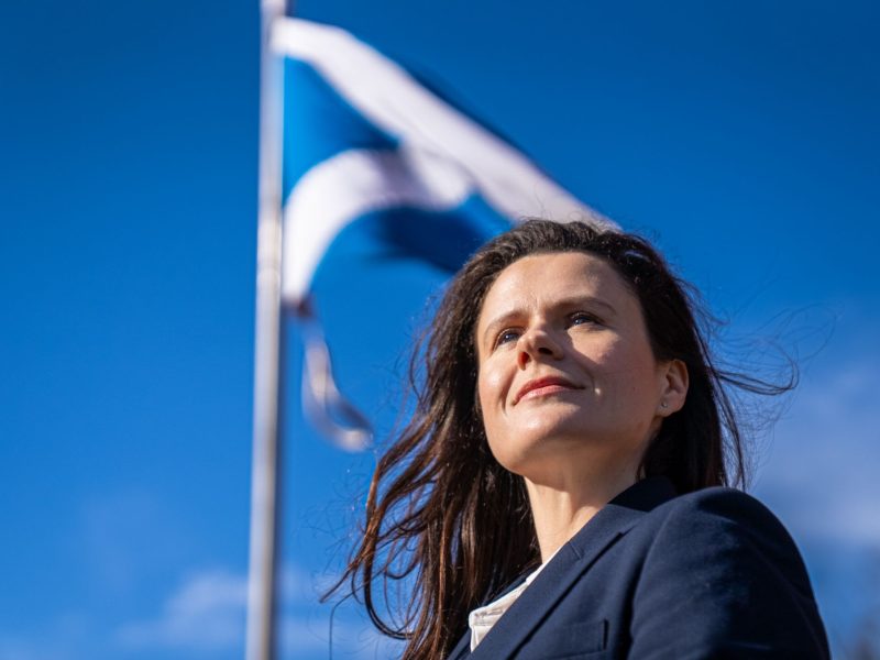 Joani Reid MP with Scottish flag (saltire) in background